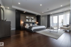 This room features dark hardwood flooring, recessed lighting, and a large glass door leading to an outdoor space - 