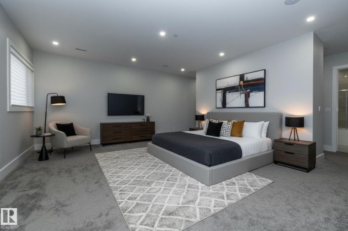 This bedroom features recessed lighting, carpet flooring, a window with blinds, and a door leading to an adjoining room - 14 3466 Keswick Boulevard, Edmonton, AB - Indoor Photo Showing Other Room