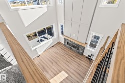 Unfurnished living room with a high ceiling, a fireplace, and wood finished floors - 