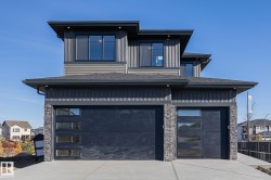 View of front facade featuring a garage, concrete driveway, and stone siding - 