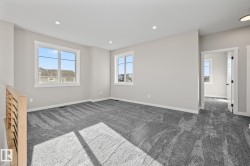 Empty room with dark colored carpet and recessed lighting - 