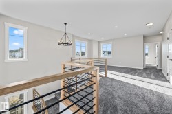 Hallway with an upstairs landing, carpet, a chandelier, and recessed lighting - 