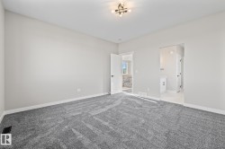 Unfurnished bedroom featuring light colored carpet and ensuite bath - 