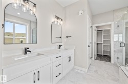Bathroom featuring double vanity, a stall shower, and a spacious closet - 