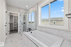 Bathroom with a garden tub, a spacious closet, and a shower stall - 