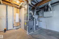 Utility room featuring heating unit, electric panel, and water heater - 