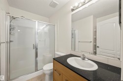 Full bath with a stall shower, vanity, a textured ceiling, and light tile patterned floors - 