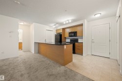 Kitchen featuring black appliances, a peninsula, decorative backsplash, light colored carpet, and brown cabinets - 