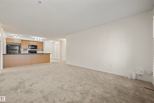 Unfurnished living room featuring light carpet and a textured ceiling - 2209 7343 South Terwillegar Drive, Edmonton, AB - Indoor