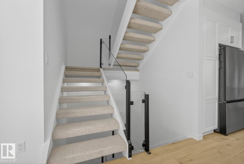 Staircase with wood finished floors and baseboards - 14502 103 Avenue, Edmonton, AB - Indoor Photo Showing Other Room