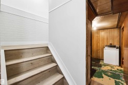 Stairs with wooden walls, washer / clothes dryer, and wooden ceiling - 