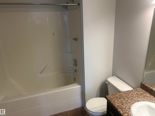 Full bath with vanity, dark tile patterned floors, and bathtub / shower combination - 411 4316 139 Avenue, Edmonton, AB - Indoor Photo Showing Bathroom