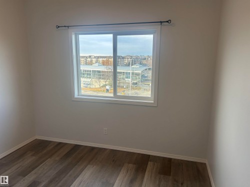 Spare room with baseboards and dark wood-style floors - 411 4316 139 Avenue, Edmonton, AB - Indoor Photo Showing Other Room