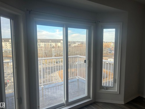 Doorway to outside with wood finished floors and baseboards - 411 4316 139 Avenue, Edmonton, AB - Indoor Photo Showing Other Room