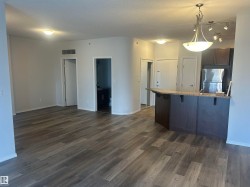 Kitchen with a kitchen breakfast bar, freestanding refrigerator, a peninsula, dark wood-style floors, and pendant lighting - 
