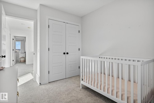 Bedroom featuring light carpet, a closet, and a nursery area - 382 Crystallina Nera Drive, Edmonton, AB - Indoor Photo Showing Bedroom