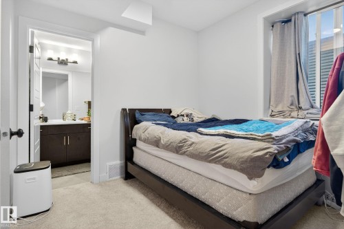 Bedroom with light colored carpet and connected bathroom - 382 Crystallina Nera Drive, Edmonton, AB - Indoor Photo Showing Bedroom