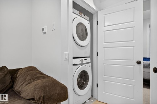 Laundry room with stacked washer / dryer - 382 Crystallina Nera Drive, Edmonton, AB - Indoor Photo Showing Laundry Room