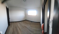 Spare room featuring wood finished floors and lofted ceiling - 