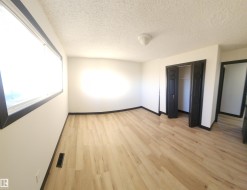Unfurnished bedroom featuring light wood-style flooring, a textured ceiling, and a closet - 