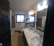 Bathroom featuring shower / bath combo, double vanity, light tile patterned floors, and tasteful backsplash - 