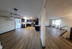 Kitchen featuring open floor plan, light countertops, stainless steel appliances, and light wood-style floors - 