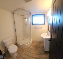 Full bathroom featuring vanity, a shower stall, and wood finish floors - 