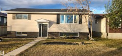 Raised ranch with a front lawn and brick siding - 