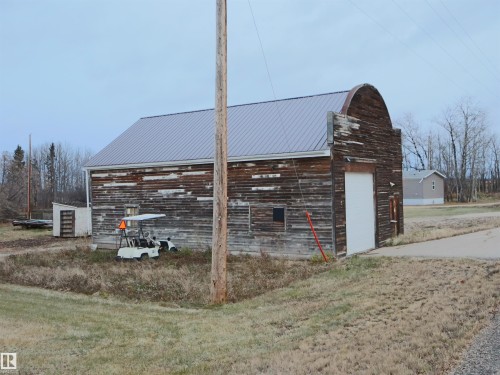 View of side of property featuring an outbuilding, a metal roof, and a garage - 4032A Twp Rd 604, Rural Barrhead County, AB - Outdoor