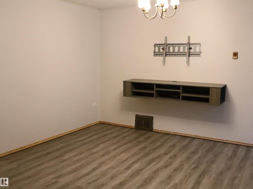 Empty room with wood finished floors and a chandelier - 4032A Twp Rd 604, Rural Barrhead County, AB - Indoor Photo Showing Other Room