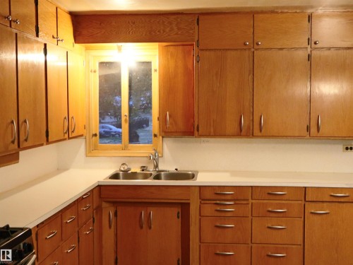 Kitchen with light countertops, brown cabinets, and stainless steel gas range - 4032A Twp Rd 604, Rural Barrhead County, AB - Indoor Photo Showing Kitchen With Double Sink