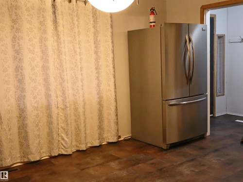 Kitchen with freestanding refrigerator and dark wood-style flooring - 4032A Twp Rd 604, Rural Barrhead County, AB - Indoor