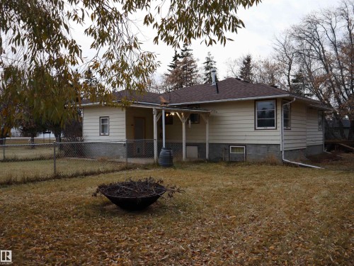 Rear view of house featuring an outdoor fire pit, a patio area, and a shingled roof - 4032A Twp Rd 604, Rural Barrhead County, AB - Outdoor