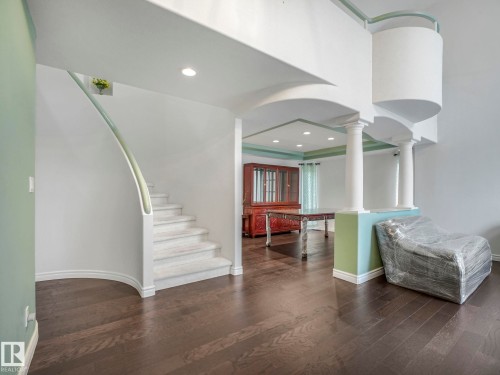 Foyer featuring dark wood-style flooring, recessed lighting, stairway, ornate columns, and arched walkways - 316 Burton Road, Edmonton, AB - Indoor Photo Showing Other Room