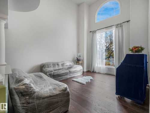 Sitting room with a towering ceiling and wood finished floors - 316 Burton Road, Edmonton, AB - Indoor Photo Showing Other Room