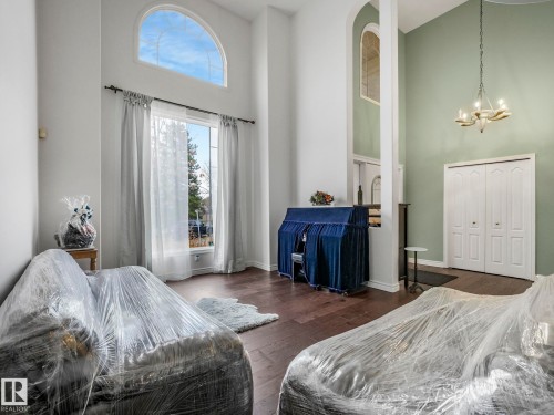 Bedroom featuring a towering ceiling, dark wood-style flooring, a closet, and a chandelier - 316 Burton Road, Edmonton, AB - Indoor Photo Showing Bedroom