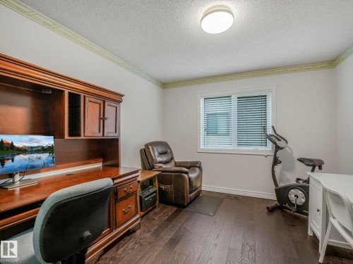 Office area with ornamental molding, dark wood-type flooring, and a textured ceiling - 316 Burton Road, Edmonton, AB - Indoor Photo Showing Office