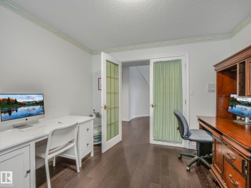 Office space featuring ornamental molding, dark wood-type flooring, french doors, and a textured ceiling - 316 Burton Road, Edmonton, AB - Indoor Photo Showing Office