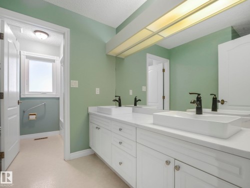 Full bathroom featuring a textured ceiling and double vanity - 316 Burton Road, Edmonton, AB - Indoor Photo Showing Bathroom