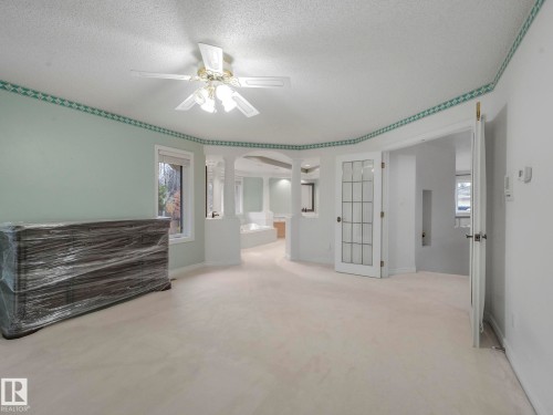 Spare room with plenty of natural light, a textured ceiling, light carpet, a ceiling fan, and arched walkways - 316 Burton Road, Edmonton, AB - Indoor