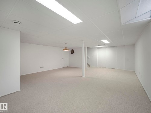 Finished below grade area featuring a paneled ceiling and light carpet - 316 Burton Road, Edmonton, AB - Indoor