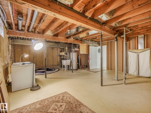 Unfinished below grade area featuring water heater and washer / dryer - 316 Burton Road, Edmonton, AB - Indoor Photo Showing Basement