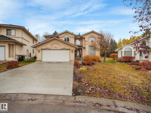 View of front of house with driveway, an attached garage, and stucco siding - 316 Burton Road, Edmonton, AB - Outdoor With Facade