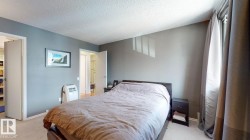 Bedroom with light colored carpet and a textured ceiling - 