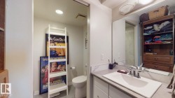 Bathroom with a closet, vanity, and light tile patterned floors - 