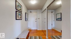 Hall featuring light wood finished floors and a textured ceiling - 