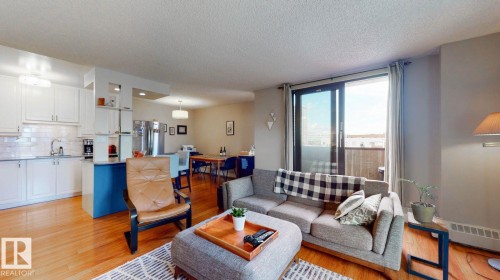 Living room featuring light wood-style floors and a textured ceiling - 301 10175 109 Street, Edmonton, AB - Indoor Photo Showing Living Room