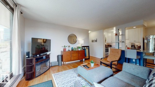 Living room featuring light wood-type flooring and a textured ceiling - 301 10175 109 Street, Edmonton, AB - Indoor Photo Showing Living Room