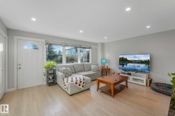 Living area with recessed lighting and light wood-style floors - 