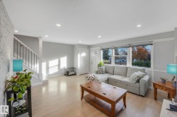 Living room with light wood-style floors, stairway, and recessed lighting - 